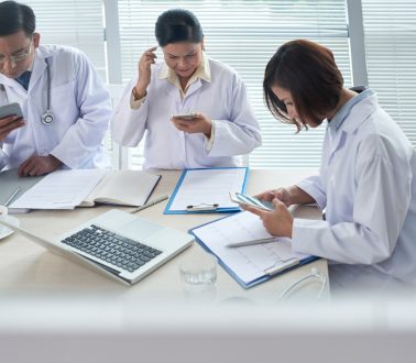 Doctors checking their phones during meeting